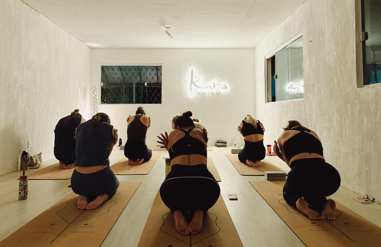 Aula de yoga na sala branca do Kura